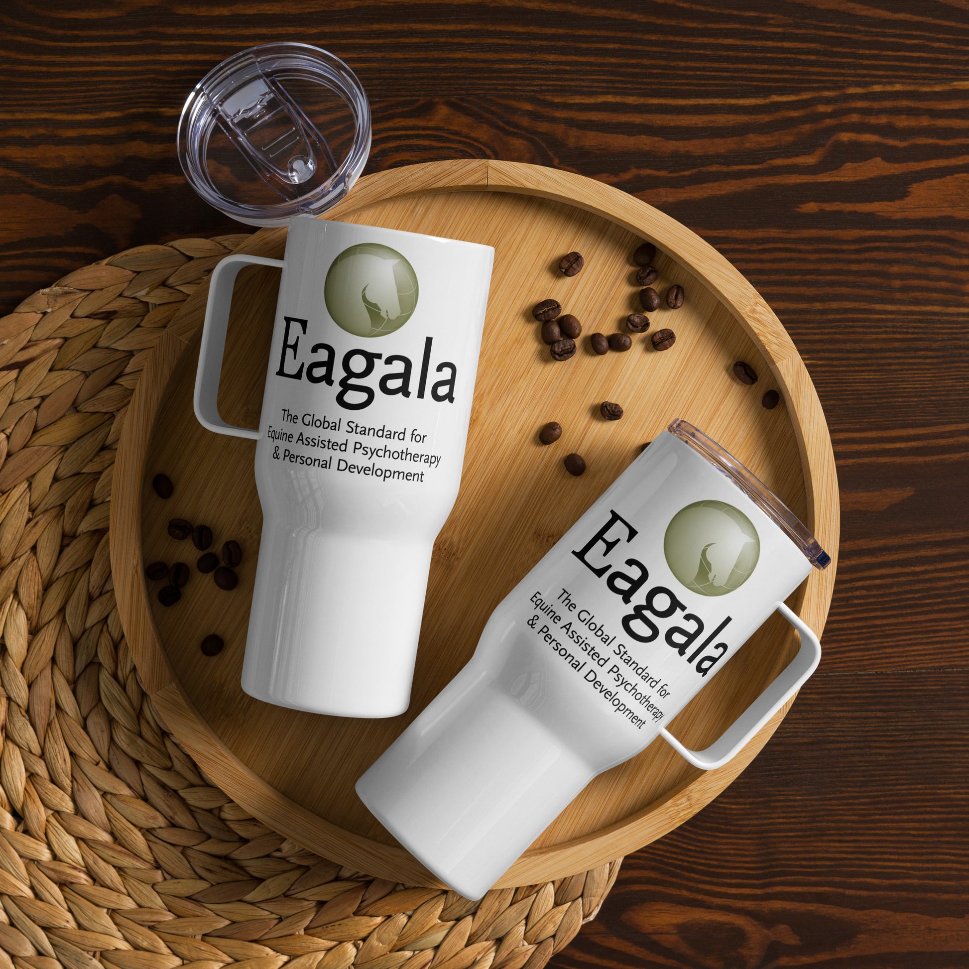 Two white mugs with Eagala branding on a wooden tray with coffee beans.